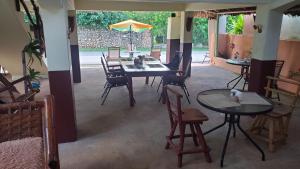 a room with tables and chairs and an umbrella at YES PAPA! Rooms at 100m from the beach! in Las Galeras