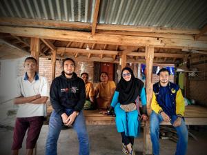 a group of people sitting on a wooden bench at Budaya Kaki Rinjani in Senaru