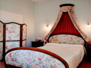 a bedroom with a bed with a red canopy at Domaine De Kerstinec/Kerland in Riec-sur-Bélon