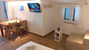 a living room with a dining room table and a couch at Stone House Bonaca with Sea View in Baška Voda