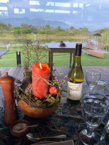 una mesa con una botella de vino y un bol de fruta en ECO Lodge Villa Villekula en The Crags