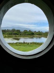 a view of a lake through a round window at ECO Lodge Villa Villekula in The Crags