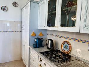 a kitchen with white cabinets and a stove top oven at Casa di Alice in Parma