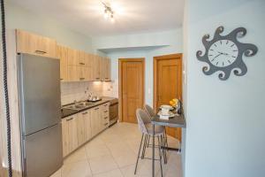 a kitchen with a table and a clock on the wall at Joy cozy apartment in Iraklitsa