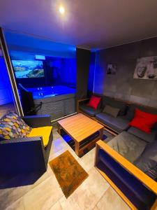 ein Wohnzimmer mit einem Sofa und einem Tisch in der Unterkunft Gites Spa Strasbourg - Gite des frères in Hurtigheim