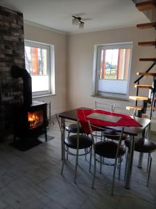 a room with a table and chairs and a fireplace at Gajówka in Radków