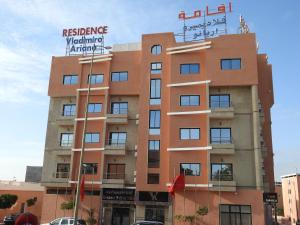 un edificio con un cartel encima en Résidence Vladimiro Ariano, en Laayoune