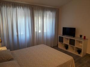 a hotel room with a bed and a television at Fontanarossa Airport Sleep and Travel in Catania