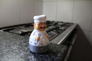 a toy chef figurine sitting on a kitchen counter at Casa da Porta de Santo António in Bragança +34 photos
