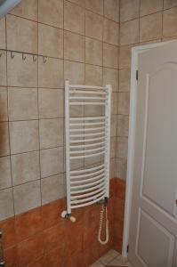 a bathroom with a radiator in a tiled wall at Herbert Apartman in Bük +16 photos