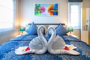 Dos cisnes como si estuvieran sentados en una cama. en The Title Residencies Naiyang Beach, en Nai Yang Beach