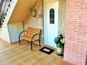 a wooden bench sitting on a porch next to a door at Casa Turistica Nigrán in Nigrán