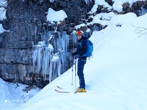 a man is standing on skis in the snow at Telemark Mountain Rooms in Agordo