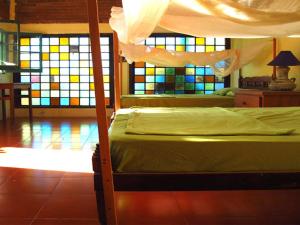 een slaapkamer met een bed en een glas-in-loodraam bij Posada Paloma in San Agustinillo