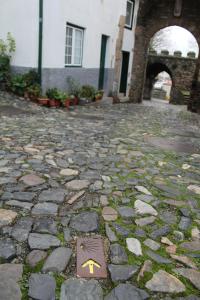 a stone walkway with a yellow arrow on it at Casa da Porta de Santo António in Bragança