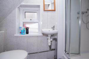 y baño con lavabo, aseo y espejo. en BIRMINGHAM HAGLEY WEST HOUSE, 5 bedrooms with 7 BEDS, 3x doubles beds, 4x singles beds,2 toilets,2 bathrooms,2 toilets, sleeps 7-10 people great motorway links M5 M6 M42 A38 A34 en Birmingham