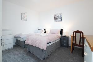 1 dormitorio con 2 camas individuales y escritorio en BIRMINGHAM HAGLEY WEST HOUSE, 5 bedrooms with 7 BEDS, 3x doubles beds, 4x singles beds,2 toilets,2 bathrooms,2 toilets, sleeps 7-10 people great motorway links M5 M6 M42 A38 A34 en Birmingham