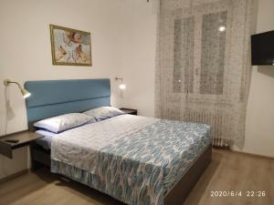 um quarto com uma cama azul e uma janela em CASA BILO em Ancona