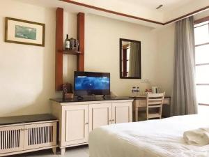 a bedroom with a bed and a desk with a television at Port Dickson Private Water Chalet in Port Dickson