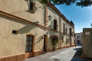 an alley in an old building with flowers on the door at Cal Mestre Casa Rural in Avinyonet