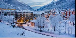 a city covered in snow with mountains in the background at Studio idéalement situé in Cauterets