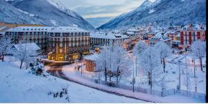 une ville couverte de neige avec des montagnes en arrière-plan dans l'établissement Studio idéalement situé, à Cauterets