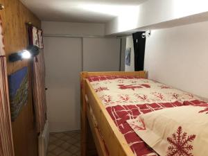 a bedroom with a bed with a red and white blanket at Petite Marmotte in Saint-Gervais-les-Bains