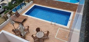 an overhead view of a swimming pool with tables and chairs at Apartamentos 250m da Orla -Edifício Nugali- Castelo B Temporada in Maceió