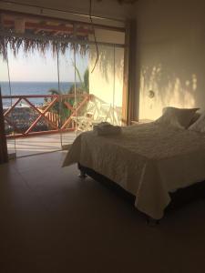 a bedroom with a bed and a view of the ocean at Origenes Spa & Lodging in Vichayito