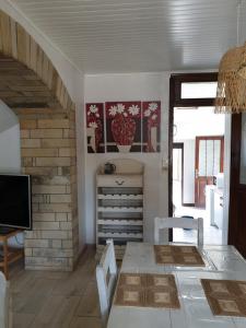 Un comedor con mesa y sillas y un televisor. en GÏTE LE CONFLUENT, en Vireux-Molhain