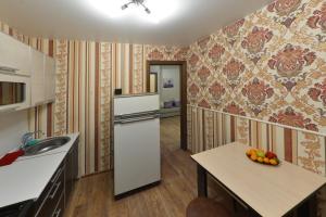 uma cozinha com um frigorífico e uma mesa com uma taça de fruta em Apartments on Tolbukhina 64 em Yaroslavl