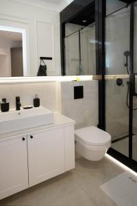 y baño blanco con aseo y ducha. en Luxury Apartments Donostia & Iruña en Belgrado