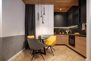 una cucina con tavolo e due sedie gialle di Luxury Apartments Donostia & Iruña a Belgrado