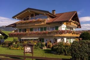 a house with flowers on the front of it at Gästehaus Alpenflora in Fischen