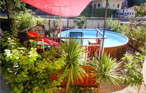 una piscina en un jardín con bañera de hidromasaje en 3 Bedroom Pet Friendly Home In Lamalou-les-bains 