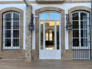 una puerta blanca en un edificio con dos ventanas en HOTEL CASABLANCA BOUTIQUE, en Linares