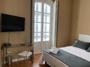 Dormitorio con cama, escritorio y TV en HOTEL CASABLANCA BOUTIQUE, en Linares