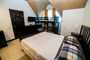 1 dormitorio con 1 cama y 2 literas en Guest House Azov Inn, en Kuchugury