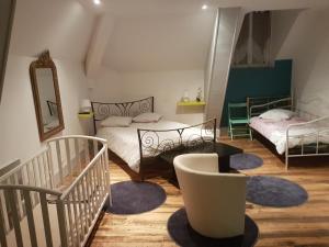 a attic room with two beds and a mirror at Le Betrot in Estissac