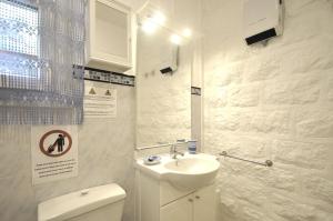 Un baño blanco con lavabo e inodoro. en Le Seigneur des Bois, en Bussière-Galant