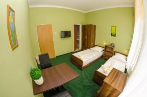 a hotel room with two beds and a table at Doby Hotelowe in Zgorzelec