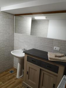 a bathroom with a sink and a toilet and a mirror at Casa Livada Bunicii in Târgu Ocna