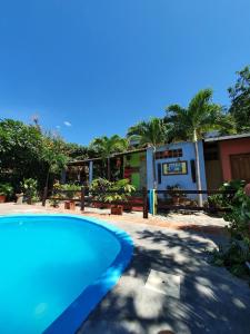 a blue swimming pool in front of a building at Hostal La Casa de Felipe in Taganga