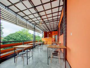 a restaurant with tables and chairs and a large window at Super OYO Capital O 90151 Guest House 180 in Batu