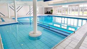 a large swimming pool in a large building at Appartement, Kaap 123 - Ameland in Hollum