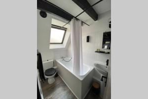 ein Badezimmer mit Badewanne und Waschbecken in der Unterkunft La Maison Sévigné - Appart Hôtel - N°6 L'indus in Béthune