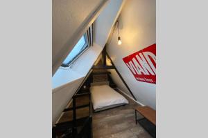 ein Zimmer mit einer Treppe mit einem Bett und einem Fenster in der Unterkunft La Maison Sévigné - Appart Hôtel - N°6 L'indus in Béthune