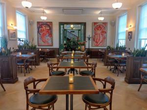 a restaurant with tables and chairs and windows at Hotel Kronacker in Tienen
