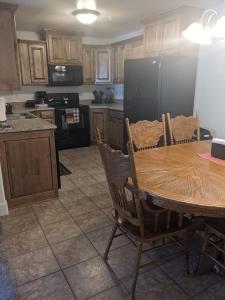 a kitchen with a wooden table and a black refrigerator at The Tuscan Lodge in Payson