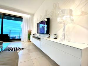 a living room with a television and a couch at Luxury Suite Koksijde 201 - Adult Only in Koksijde